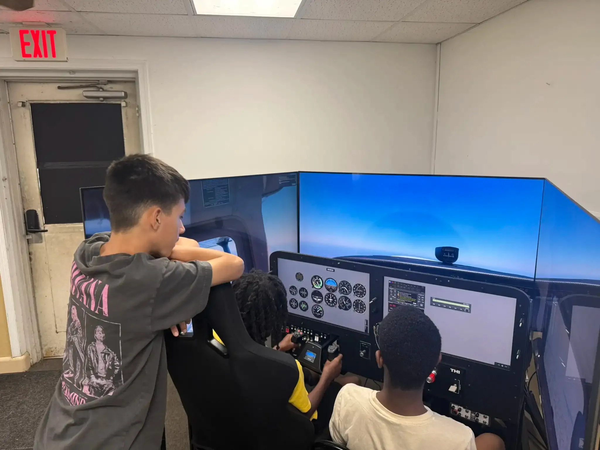 Camper with hands on the controls of an FAA-approved simulator at Solid Ground Aviation