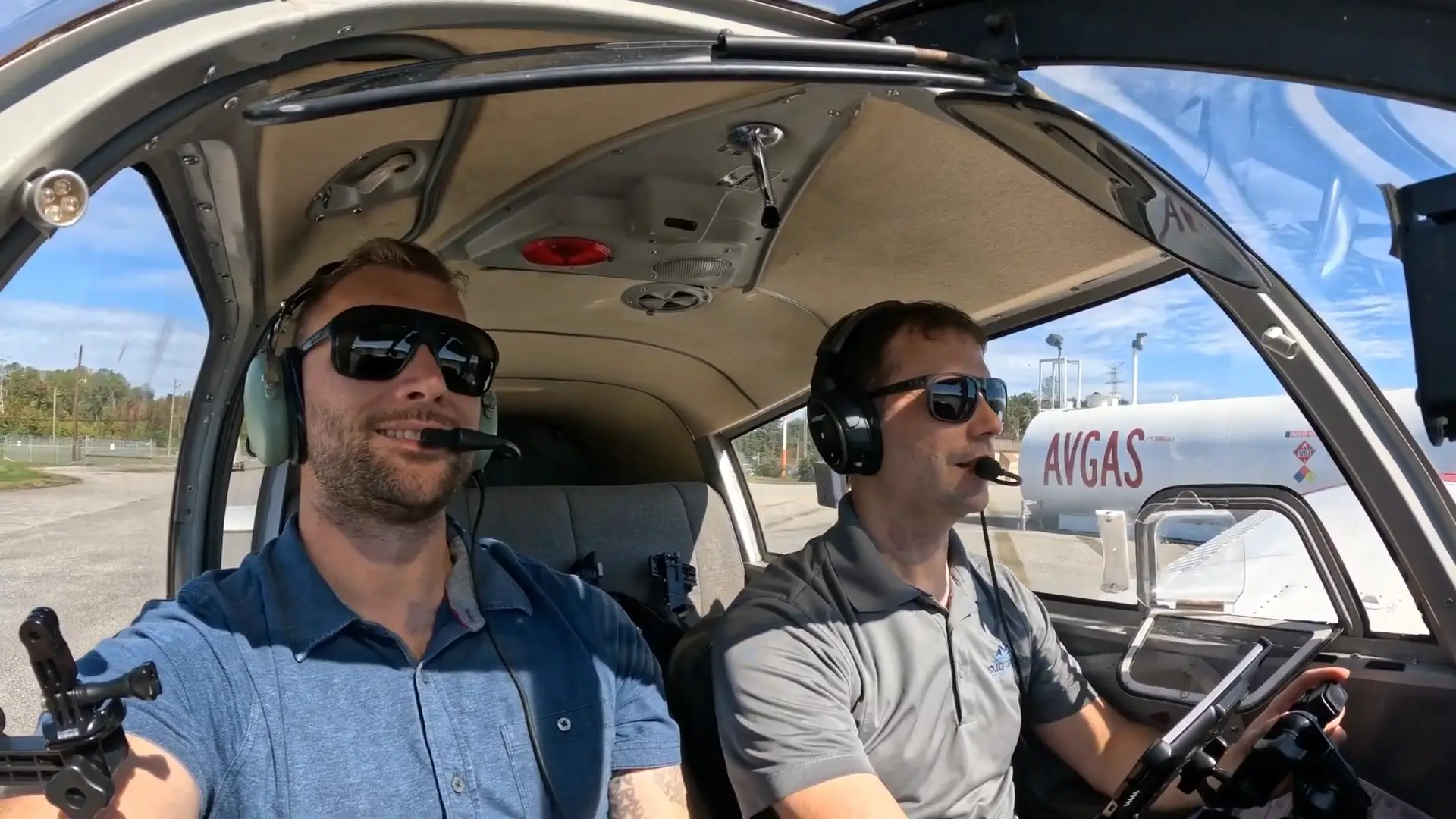 Pilots smiling inside plane on ground