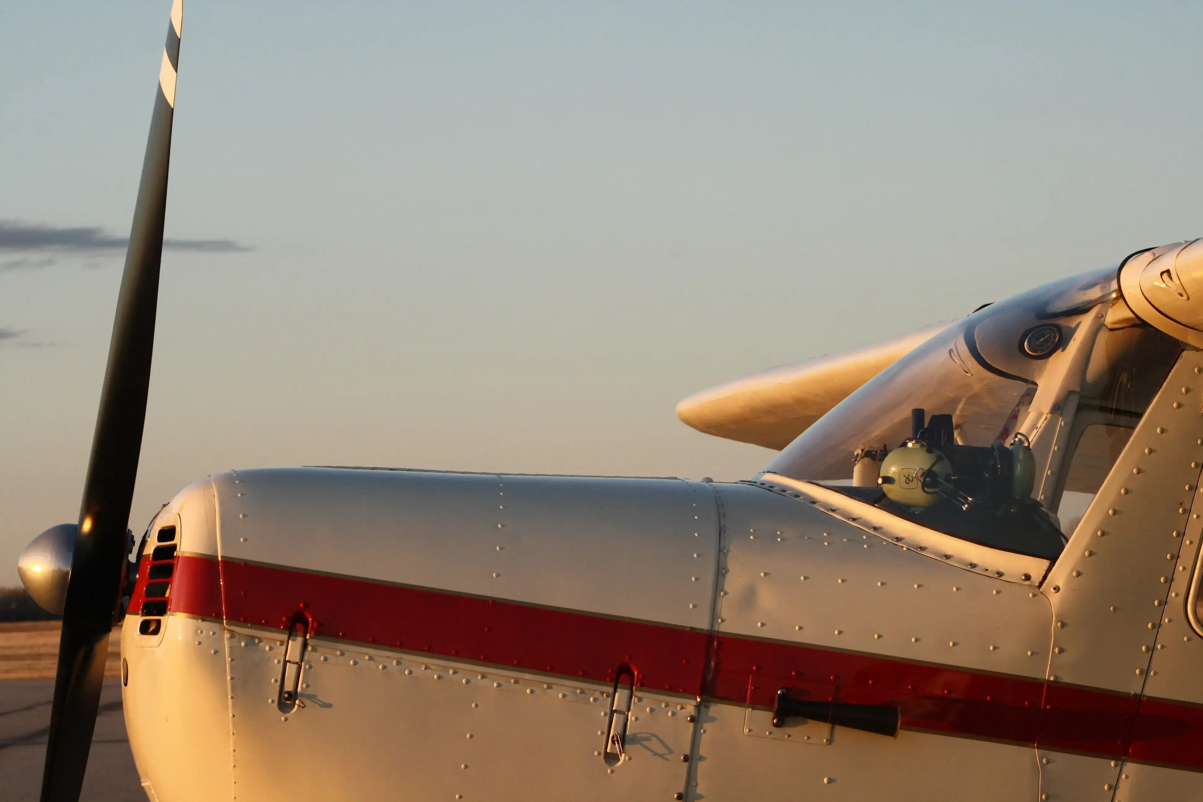 Nose and propeller of a Cessna parked on the ramp at sunset