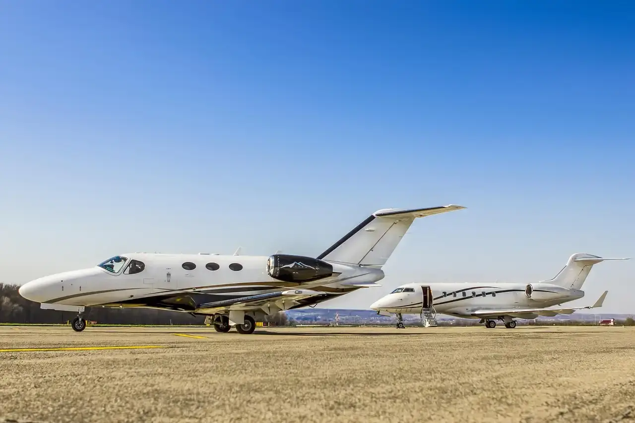Two business jets parked on a sunny ramp