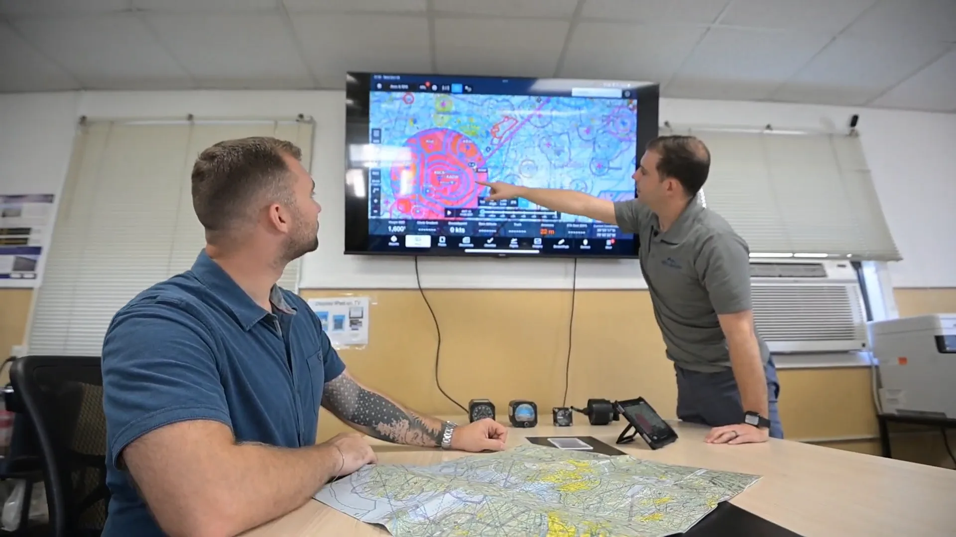 Instructor explaining approach charts to a student pilot before instrument training